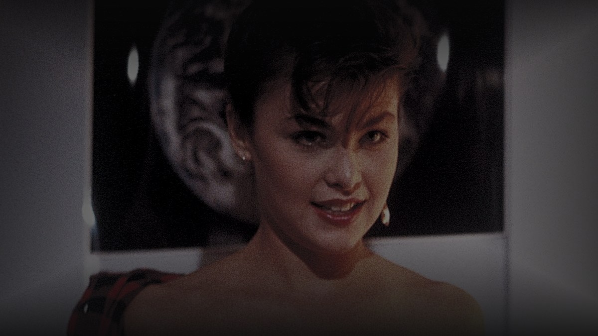 Still from Just One of the Guys (1985) — 16:9 still from Letterboxd (the 1200x675 crop variant), baked through scripts/bake_dark_photo.py at default factor, mean brightness 38.8 (in canon range, slightly above the 25-35 target but appropriate for a bright 80s comedy).