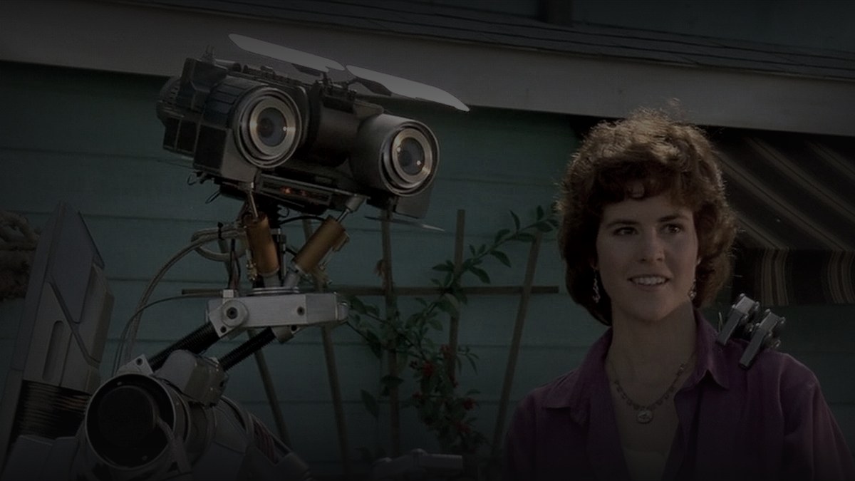 Still from Short Circuit (1986) — letterboxd still, pre-brightened 1.40 + baked at factor 0.45 (mean 31.4)