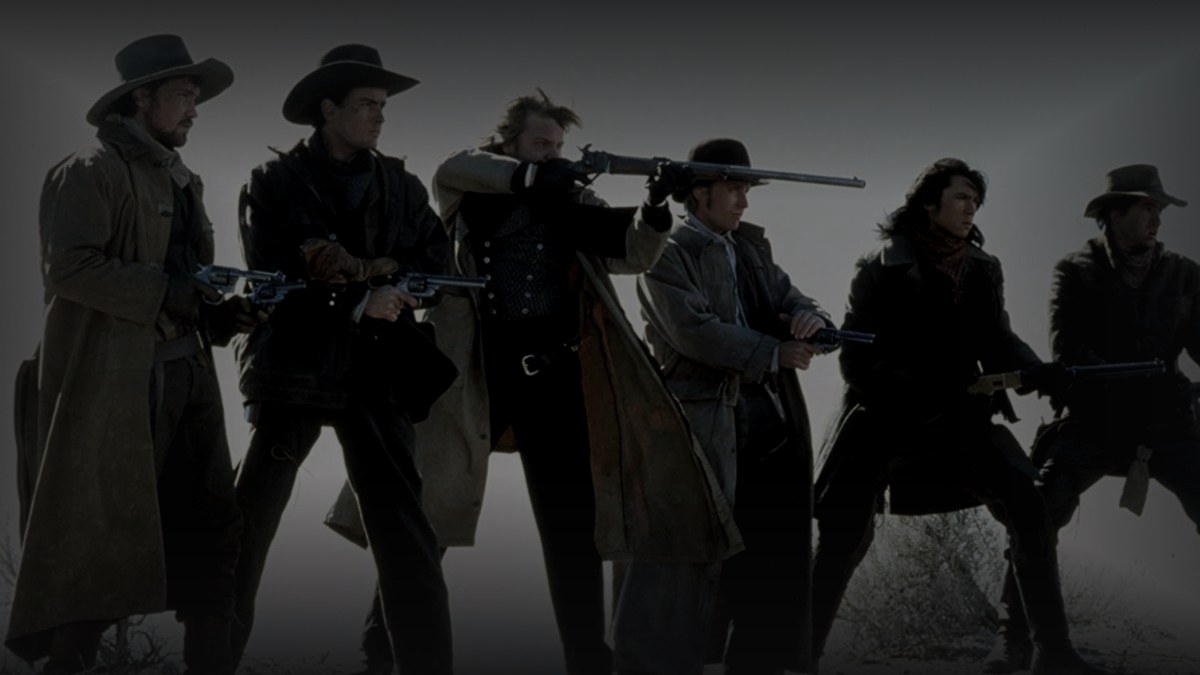 Still from Young Guns (1988) — 16:9 still from Letterboxd (the 1200x675 crop variant), baked through scripts/bake_dark_photo.py at default factor, mean brightness to be verified after bake. source: the young guns regulators ensemble, the canonical still for the film.